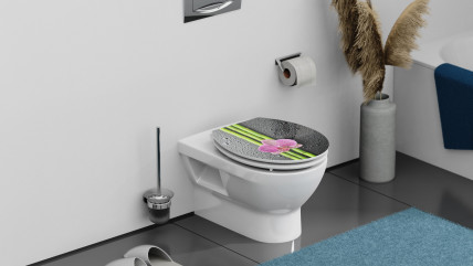 Toilettensitz mit Bambusmotiv und pinker Orchidee vor Verpackung mit Herstellerlogo.